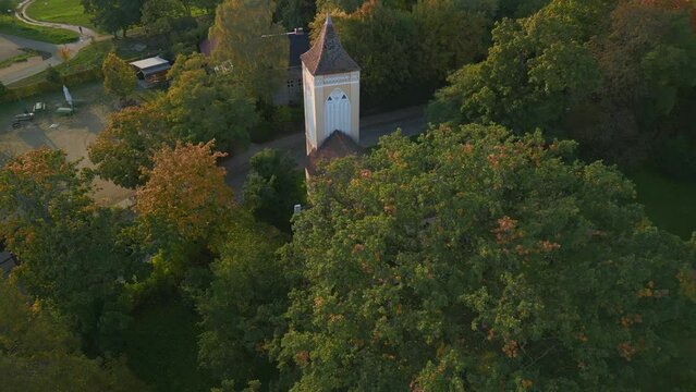 Bell tower of a german village church Havelland. Smooth aerial view flight drone