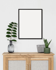 Empty vertical frame mockup in modern minimalist interior with plant in trendy vase on white wall background, Template for artwork, painting, photo or poster