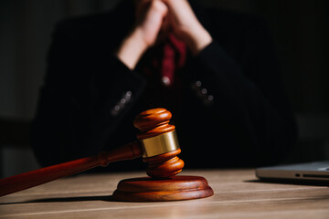 Justice and law concept.Male judge in a courtroom with the gavel, working with, computer and...