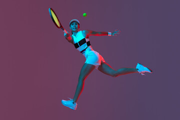 Fototapeta na wymiar Studio shot of active professional tennis player training with tennis racket over gradient pink-purple background in neon light. Sport, fashion, ad