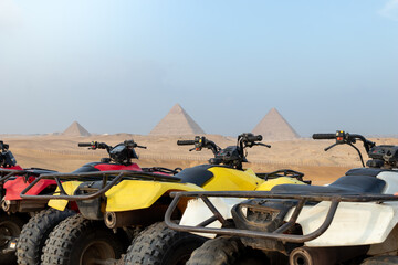 Colorful parked quad bikes ATV safari in desert with pyramids in background Cairo, Egypt.