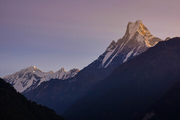 Obraz premium Mt. Machhapuchhre, or Fishtail, seen from Chhomrong, a village on Annapurna base camp trekking, Nepal. Himalaya mountains at sunrise.