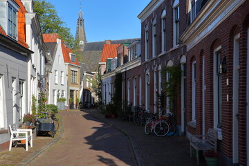 The historic city center of Weesp, a small town located in the East of Amsterdam, North Holland, Netherlands, with historic houses along Middenstraat street and St Laurenskerk church in the background