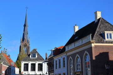 Obraz premium The historic city center of Weesp, a small town located in the East of Amsterdam, North Holland, Netherlands, with historic houses along Nieuwstraat street and Saint Lawrence (Laurentius) church