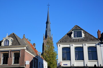 Fototapeta premium The historic city center of Weesp, a small town located in the East of Amsterdam, North Holland, Netherlands, with historic houses along Nieuwstraat street and Saint Lawrence (Laurentius) church