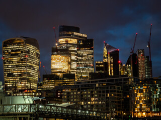 Fototapeta na wymiar London, UK - City of London Financial District lit up at night with skyscrapers and office blocks early evening. Business HQ, Economy, GDP, Making money, Banking and Wall Street style concept