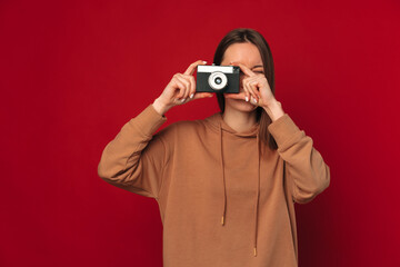 Beautiful young woman practices her hobby and takes a picture with her camera.