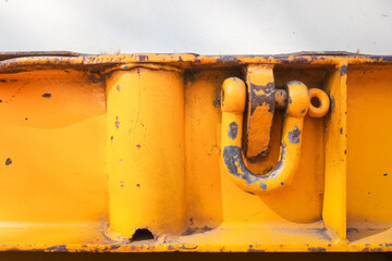 Heavy metal shackle with bolt which is installed on the cargo trailer side, using as latching anchor to secure the loading object. Industrial safety equipment, selective focus.