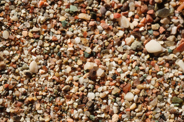 Closeup Macro shot of small yellow and brown grains of sand lying on the seashore on a bright sunny day