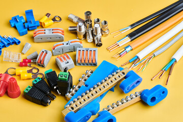Obraz premium Different electrical tools isolated on yellow background, electrician equipment, wires, terminals, connectors, fuses, switches