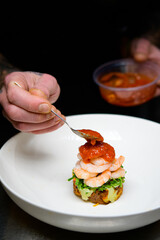 Chef's finishing touches to prawn dish
