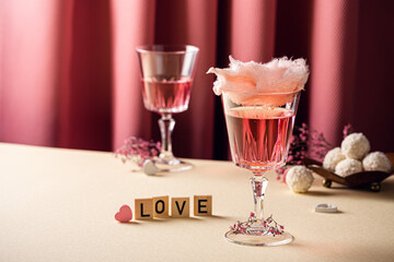 Romantic composition with Valentines day drinks, glasses with tasty cotton candy champagne on pink...