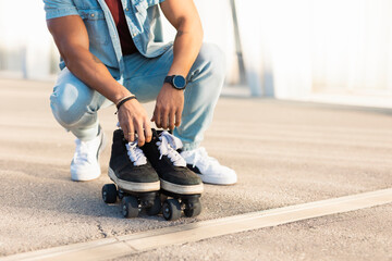 Obraz premium Black man enjoy outside. Modern man posing with roller skates..