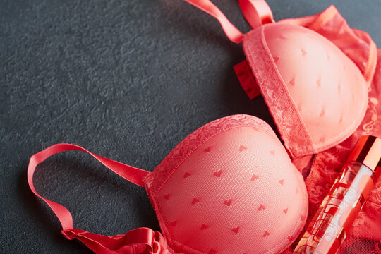 Red sexy bra and panties in box on black background. Women sexy underwear  set with roses and perfume. Gift Idea for Womens Day or Valentines day with  copy space. Surprise for men or for him. Top view Stock Photo