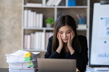 Asian businesswoman are stressed while working on laptop, Tired asian businesswoman with headache at office, feeling sick at work.