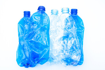 Plastic bottles, blue and transparent, crushed. Waste and plastic pollution, plastic recycling. 
