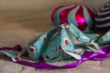 Heap of festive wrapping paper from gifts, ribbon and ballons throughout the bed. Unpacking holiday...