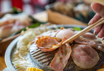 Closeup of grill with deliciouse seafood, shrimp, crab, mussle, pork sausage and vegetable on wood table in BBQ grill restaurant from thailand