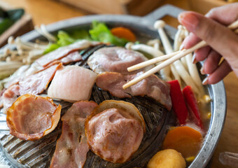 Closeup of grill with deliciouse seafood, shrimp, crab, mussle, pork sausage and vegetable on wood...