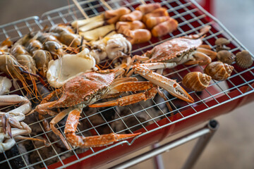 Wood Table with deliciouse seafood, shrimp, crab, mussle, pork saussage and vegetable in bbq grill restaurant from thailand
