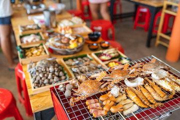 Wood Table with deliciouse seafood, shrimp, crab, mussle, pork saussage and vegetable in bbq grill...