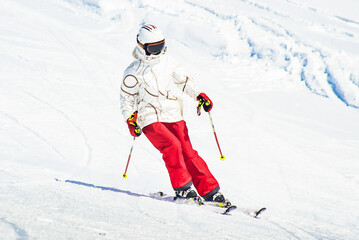 Alpine ski. Skiing woman skier going downhill against snow covered isolated white ski trail slope...