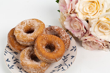 Plato con rosquillas hechas en casa y ramo de rosas.