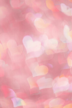 Abstract blurred vertical background with pink pastel color hearts, blurred lights as hearts bokeh, love or romance holiday fon, valentine Day festive screensaver or backdrop, color gradient