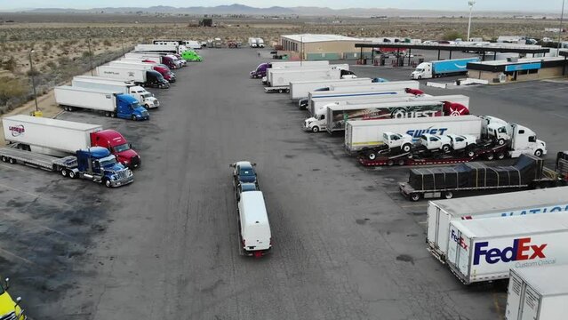 Get an aerial view of a pickup truck towing a carhauler in this review and inspection video. Watch as the semi truck makes a pitstop at a gas station, showcasing its capabilities on the road