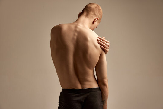 Healthy spine. Image of male strong, relieve, muscular back over grey background. Young model posing in underwear. Concept of men's health and beauty, body and skin care, fitness. Body art