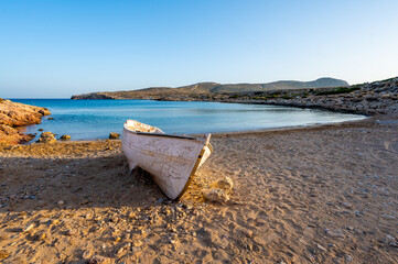 Old wooden fishing boat on a sandy Tendopoula beach, Crete Greece.