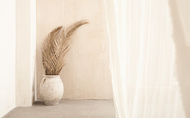 light still life with dry palm leaves in a beige vase. Topics of relaxation and recuperation