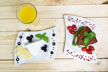 Sandwich with cheese and tomato with orange juice on a wooden background — flat lay