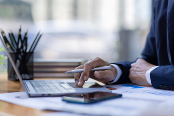 Businessman accountant or financial expert analyze business report graph and finance budget chart in the office. Concept of finance economy, banking business and stock market research.