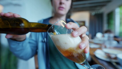 Person serving beer inside glass taking a sip too much foam