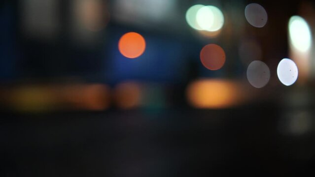 Bokeh car lights in the evening city. Defocused headlights and street lighting at night. Moving bokeh circles of cars at night. Blurred city traffic background