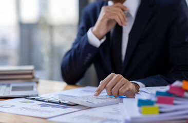 Businessman accountant or financial expert analyze business report graph and finance budget chart in the office. Concept of finance economy, banking business and stock market research.