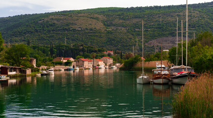 Fototapeta na wymiar sailing boats at anchor berthed in small river at Kolomac Dubrovnik Croatian small touristic town