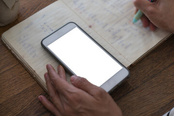 Close up focus on employee use smart phone with notebook on desk, busy officer doing many job task concept for business technology.