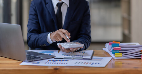 Businessman accountant or financial expert analyze business report graph and finance budget chart in the office. Concept of finance economy, banking business and stock market research.