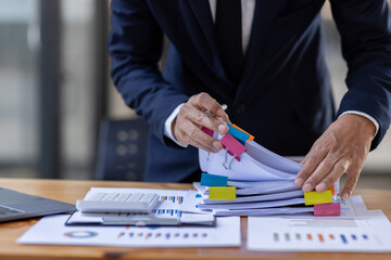 Businessman accountant or financial expert analyze business report graph and finance budget chart in the office. Concept of finance economy, banking business and stock market research.