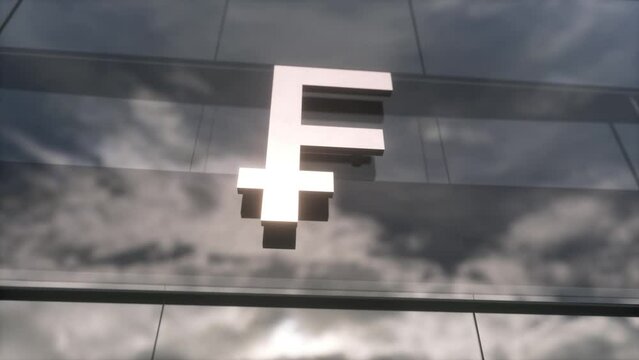 Franc symbol currency sign on a modern glass skyscraper. Mirrored sky and city on modern facade. Business and finance concept