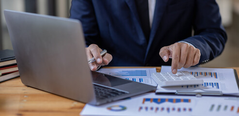 Businessman accountant or financial expert analyze business report graph and finance budget chart in the office. Concept of finance economy, banking business and stock market research.