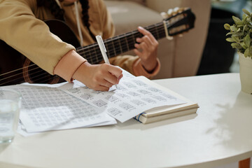 Closeup image of girl practicing exercise for her acoustic guitar class