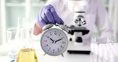 Doctor scientist holding alarm clock in laboratory - Powered by Adobe