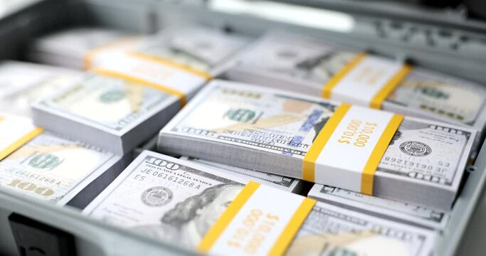 Briefcase full of stacks of dollar bills and financial success