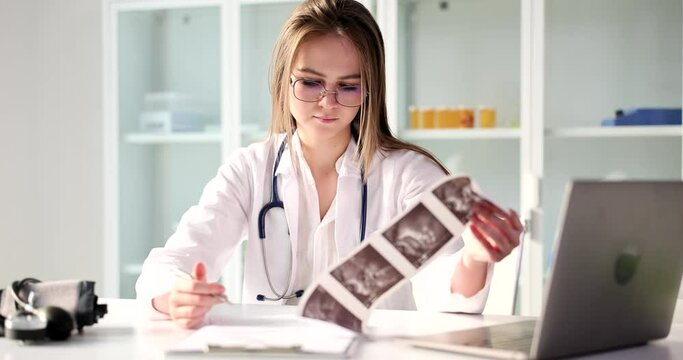 Doctor gynecologist examines result of ultrasound examination of uterus in clinic