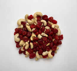Mixture of cashew nuts and dried berries on white background. Copy space, top view, close-up.