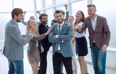 Fototapeta premium triumphant group of staff congratulating their leader