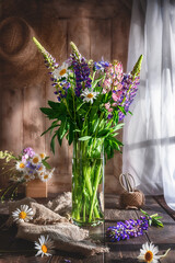 vase with wildflowers. lupines, daisies, cornflowers